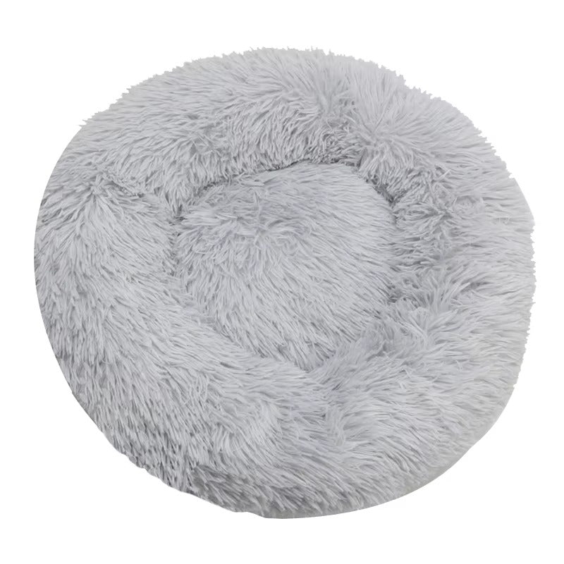 Round, fluffy gray pet bed on a white background